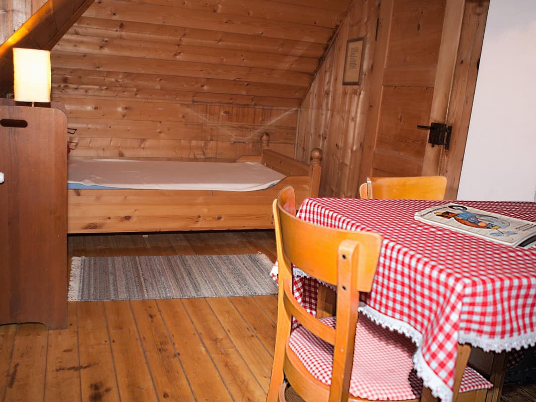 Holztisch mit 3 Stühlen vor Bett