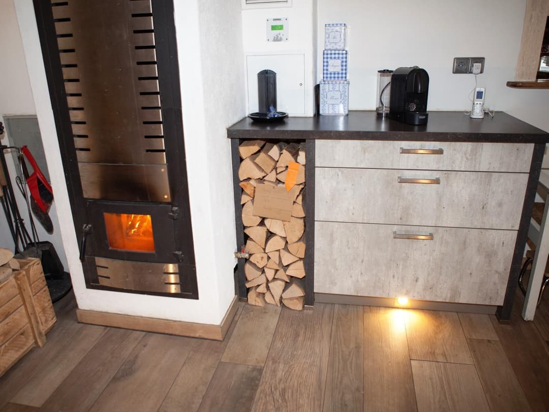 Inaktiver Kamin mit Holzstapel und einem Seitenschrank in Küche