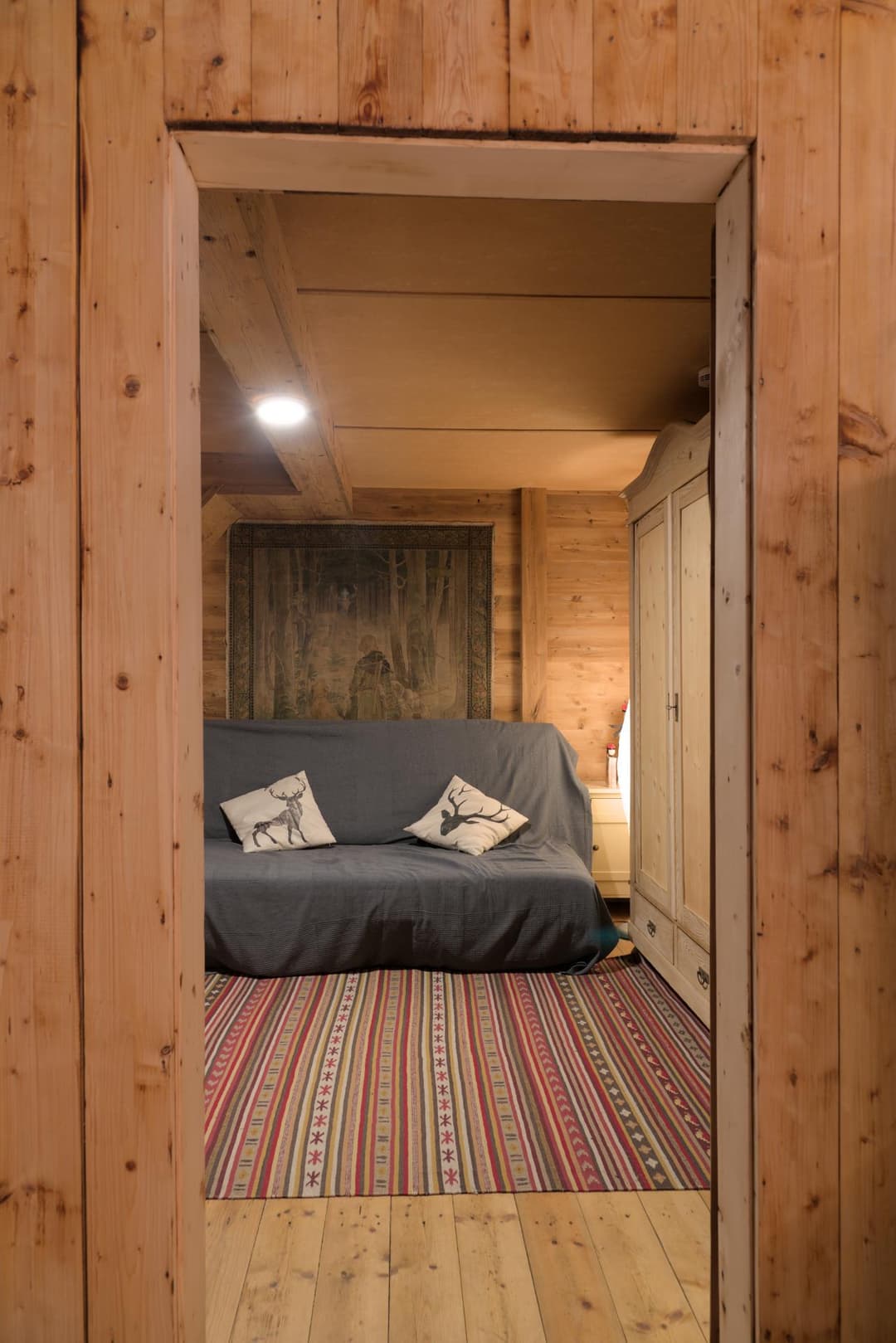 Graues Schlafsofa in kleinem Zimmer mit warmer Beleuchtung