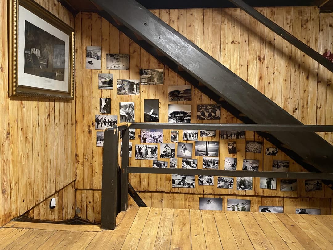 Schwarze Holztreppe mit Bilderwand